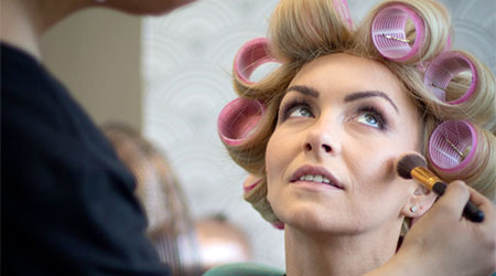 Client in rollers having her make up done professionally