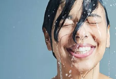 Lady smiling with wet hair and water on hair and face