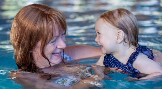 smiling client with baby in swimming pool