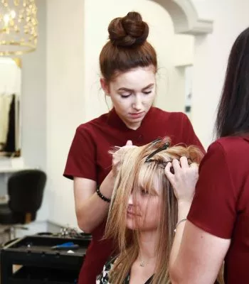 Female member of staff working on clients hair system