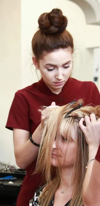 Experienced Hair Solved female hair loss technician working on clients hair system