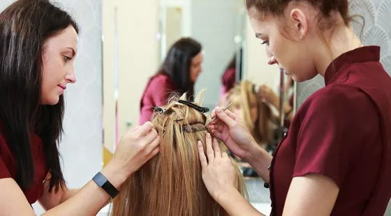 Two female team members creating a hair system