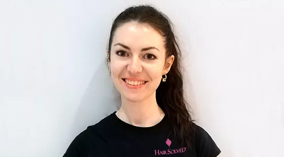 Female member of staff happy and smiling wearing uniform