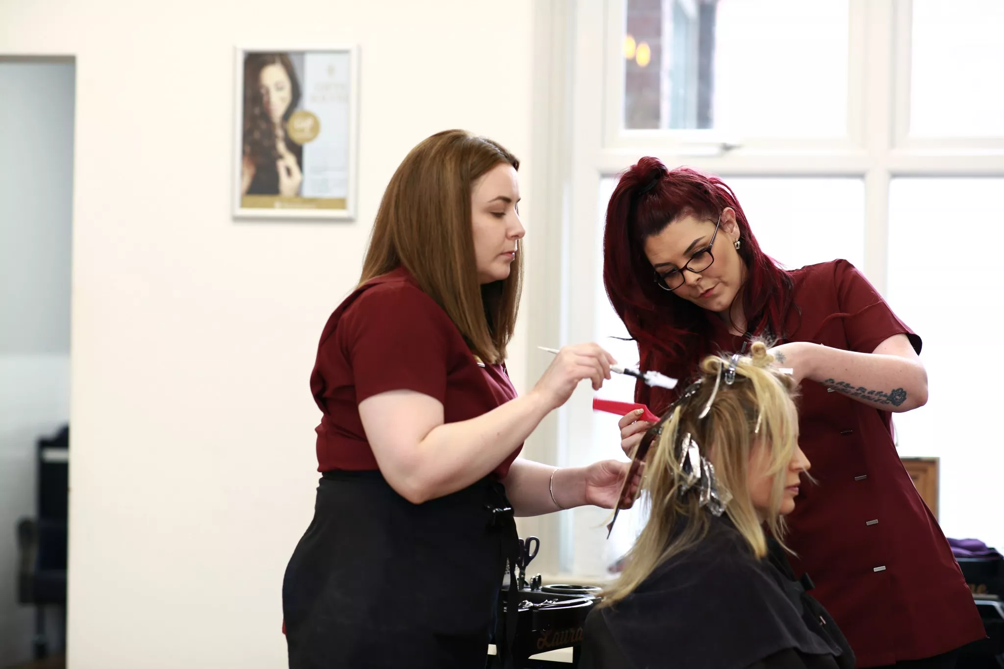 Rachael working closely with another female member of the team colouring a clients hair