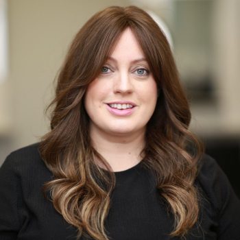 Female hair loss Client Claire smiling with long beautiful brown Enhancer System with gentle curls
