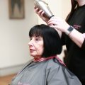 Sue with a member of the salon team during a hair system appointment after her blow dry